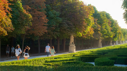 Personas paseando al atardecer por el Parque del Buen Retiro de Madrid