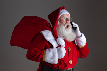 Santa Claus using a smartphone. Surprised.