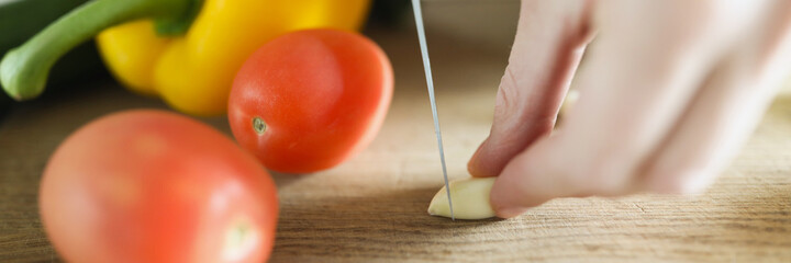 Chef hands are cutting fresh vegetables on cutting board closeup