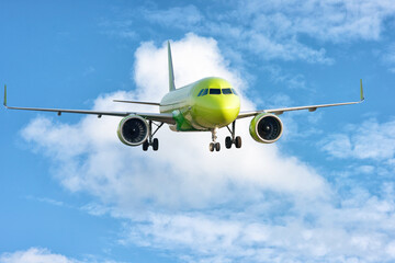 A big yellow jet flying on background of blue sky.