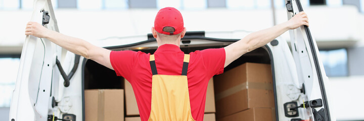 Male courier opening minivan car with many cardboard boxes