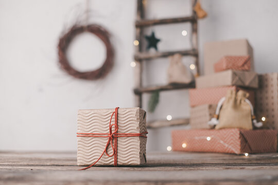 Christmas Gift Box Wrapped In In Craft Paper With Red String On The Background Of New Year's Composition. Zero Waste, Plastic Free. Space For Text