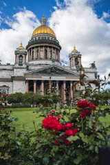 Fototapeta na wymiar Saint Isaac's Cathedral and bushes of red roses. Saint Petersburg, Russia