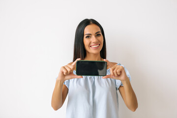 Happy beautiful young womanholding blank screen mobile phone isolated over white background
