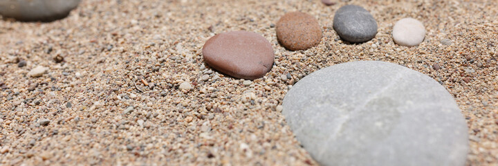 Fototapeta na wymiar Small feet are laid out of stones on stove on sea beach closeup