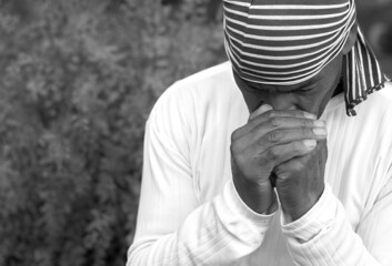 man praying to god with hands together stock photo