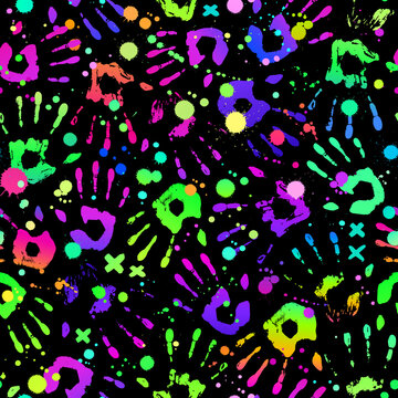 Bright rainbow handprints on black background and paint drops