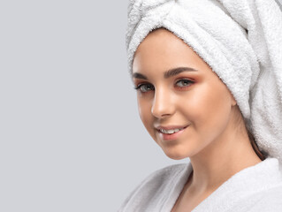 Portrait of a beautiful brunette girl in a white coat, with healthy clean skin and fresh make-up....