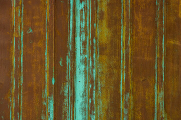 rusted corrugated steel sheet with leftovers of decayed and washed out green paint
