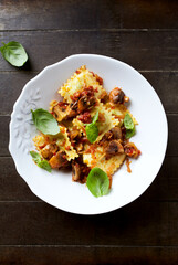 Ravioli with mushrooms and fresh basil. Dark wooden background. Top view.