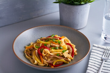 tsuivan traditional mongolian dish with meat vegetables homemade pasta grey gray background