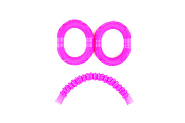 Smile from plastic corrugated tube, pop tube. trending toy of 2021. anti-stress sensory plastic toy from a tube of pink and blue color on an isolated white background. Flat lay with place for text.