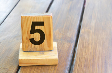 Wooden priority number 5 on a plank tab