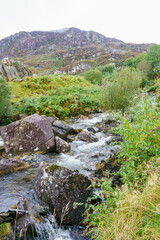 Naklejka na ściany i meble Cwmorthin waterfall, flowing river and slate quarry spoils above the Tanygrisiau reservoir at Tanygrisiau, Blaenau Ffestiniog Wales UK
