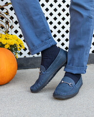 A man wearing navy blue formal loafers footwear with matching pants and dark accenting socks in the...