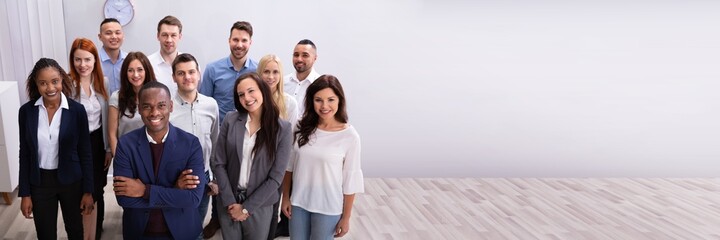 Obraz premium Group Of Smiling Businesspeople Standing In Office