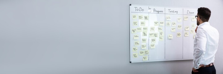Businessman Looking At Adhesive Note On Board