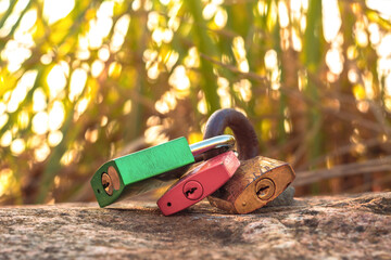 Three rusty metal love locks on a stone