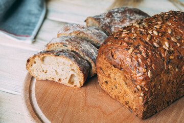Two different homemade rye breads on a cutting board through the ears. One is cut into slices of Whole Grain Seed Rye Bread.