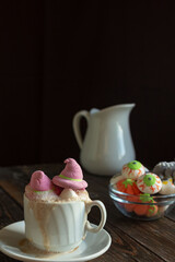 A mug of coffee, cocoa with marshmallows . Serving dessert for Halloween. Festive concept