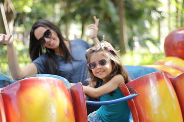 mãe e filha no parque de diversão