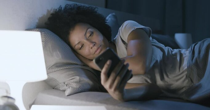 Sleepless woman connecting with her phone at night