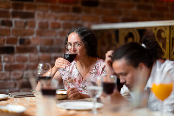 Woman having a glass of wine at family celebration in restaurant