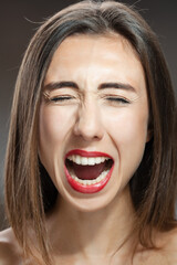 Beautiful brunette girl studio portrait. Screaming and surprised expression.