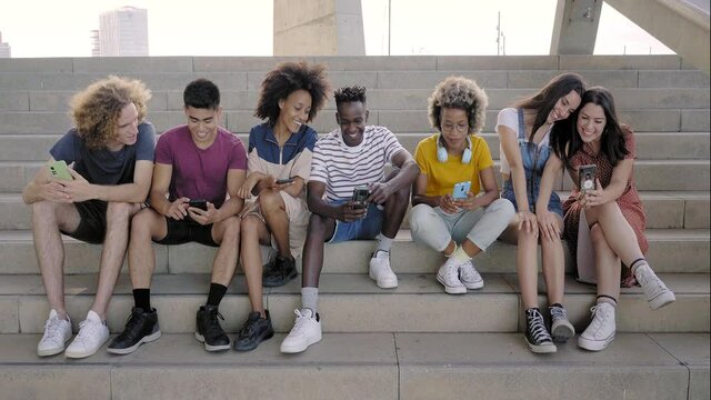 Portrait of a group of mixed race people with smart phones. Excited students using their technological devices