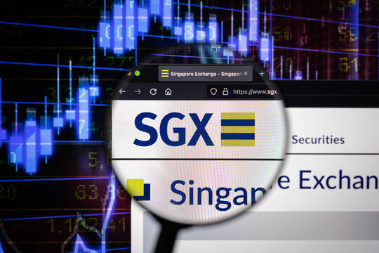 SGX company logo on a website with blurry stock market developments in the background, seen on a computer screen through a magnifying glass	