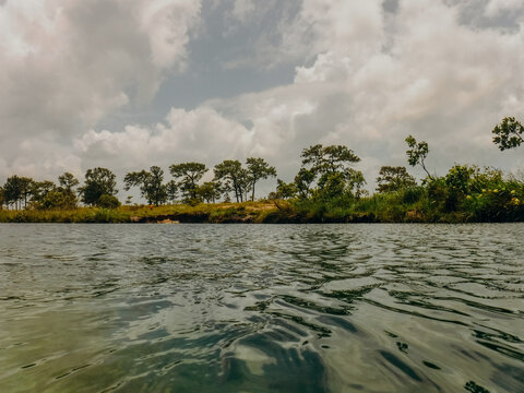 River in Honduras with green trees and cloudy sky