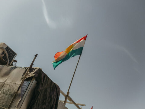 Kurdish flash on flagpole against clear grey sky