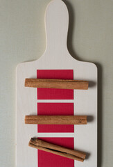 three cinnamon sticks on red paper squares