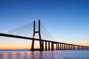 Fototapeta na wymiar Long exposure shot of Vasco da Gama bridge in Lisbon before sunrise