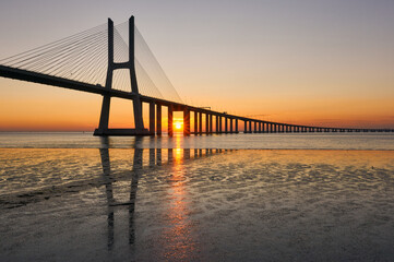 Fototapeta na wymiar Long exposure shot of Vasco da Gama bridge in Lisbon at sunrise