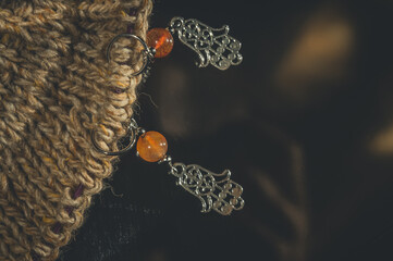 Decorative markers for knitting. Metal and stone. Hand knitting. Dark background, close-up, copy space, horizontal composition