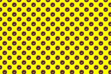Black donuts with red glaze on yellow background seamless pattern top view. Food dessert flatly flat lay of delicious sweet nibbles chocolate donuts