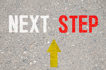 Next steps progress concept with chalk text and direction arrows on blackboard or chalkboard.