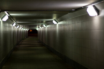 Lighting in the tunnel. Pedestrian crossing with lamps. LED light in a long tunnel under the track.