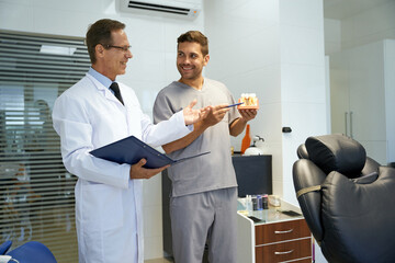 Two male dentists having a professional discussion at clinic