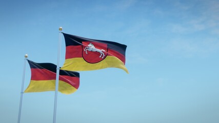Waving flags of Germany and the German state of Niedersachsen against blue sky backdrop. 3d rendering