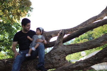 Naklejka na ściany i meble Pai e filha no tronco de uma árvore sentados