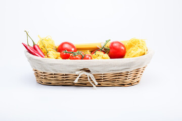 Obraz na płótnie Canvas Basket with cherry tomatoes, tomatoes, red hot chilli pappers spaghetti, tagliatelle 