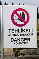 A bilingual sign in Turkish and English warns people to stay out of a dangerous area
