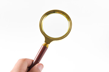 hand holding brass magnifying glass isolated on white background