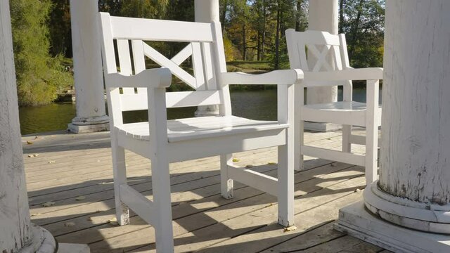 The Small White Wooden Chair On The Gazeebo Beside The Lake In The Park In Estonia