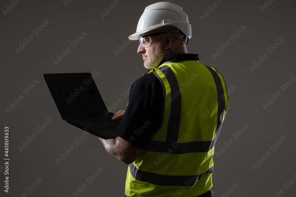 Poster builder laptop with screen off. man in uniform of construction worker. concept - software for builde