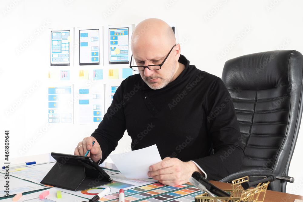 Poster ux designer in workplace. mockups of mobile applications behind man back. ux designer works in a web