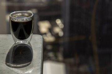 Black coffee in glass cup on marble table in the morning. Coffee style, Copy space, Selective focus.