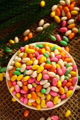 Bowl of colorful Indian cumin seed candy on  a rustic background.
